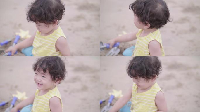 可爱的男孩在沙滩上玩沙子和快乐。