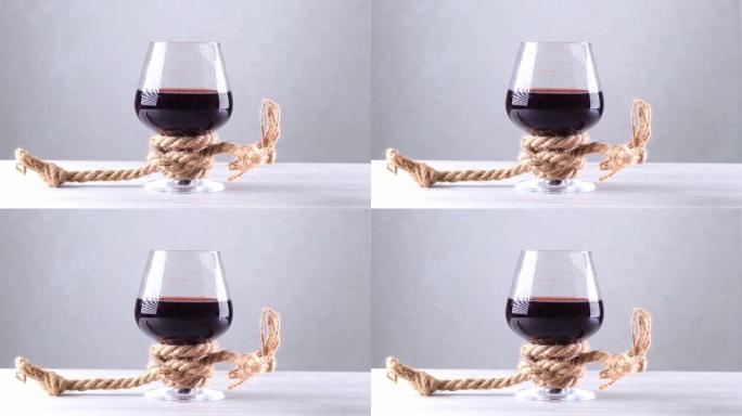 酒杯用绳子绑着。酒精依赖的概念