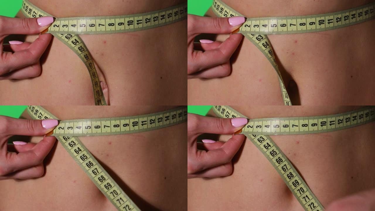 女孩测量腰部，保护良好的营养和健康的生活方式。