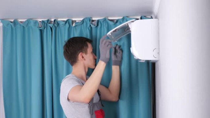 工作服中的专注杂工用螺丝刀卸下螺丝