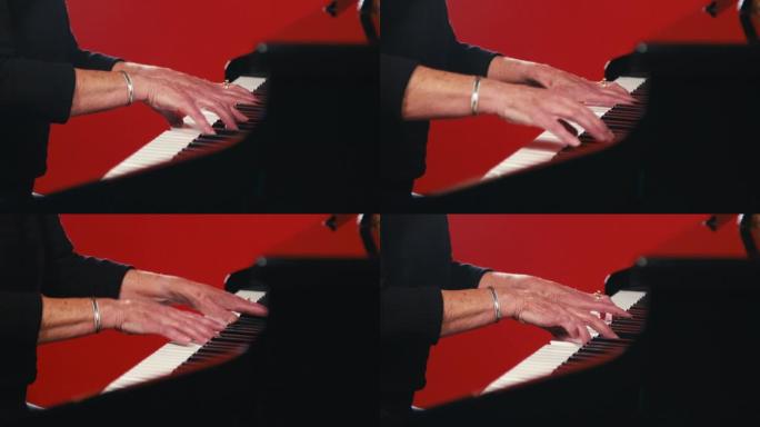 一个成年白人妇女的手在红色工作室背景前在钢琴上演奏长时间的和弦的特写静态镜头