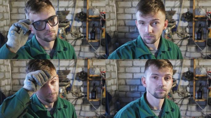 工作服专业机械师脱下防护眼镜，擦去额头上的汗水。疲惫的年轻修理工在车库里看着相机的肖像。维护服务理念