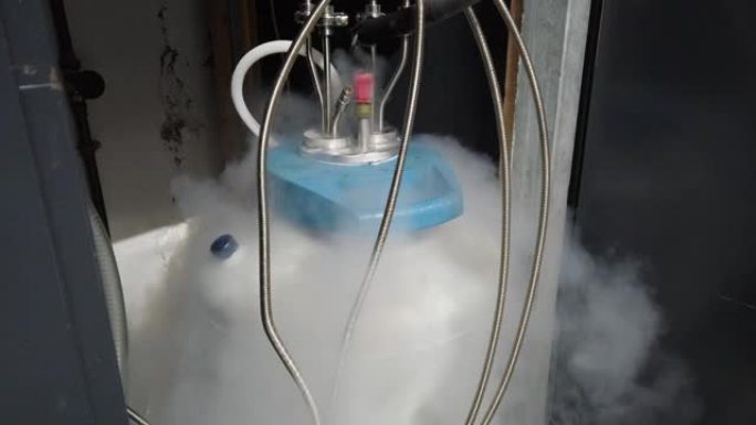 白色冷凝蒸汽从带有金属管道的液氮罐中流出