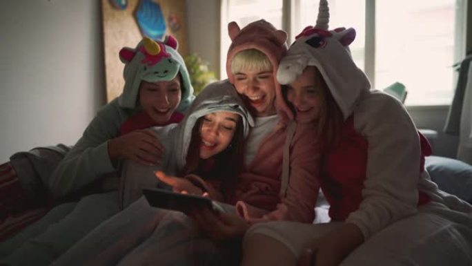 在智能手机上查看社交媒体时，在过夜的快乐女友们玩得开心。