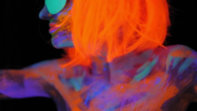 一个脸上有紫外线图案的女孩，戴着橙色假发和绿色眼镜