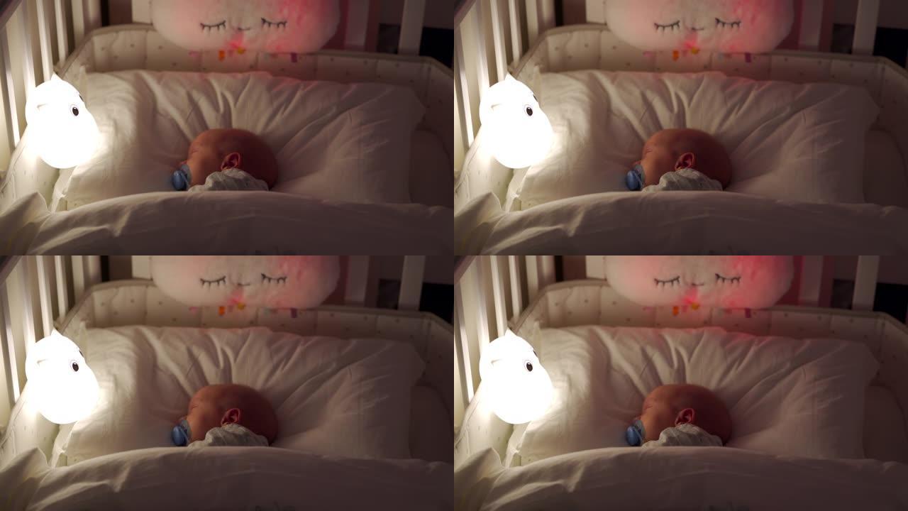 新生儿男婴晚上睡在床上，3周大的婴儿在夜灯下睡觉。