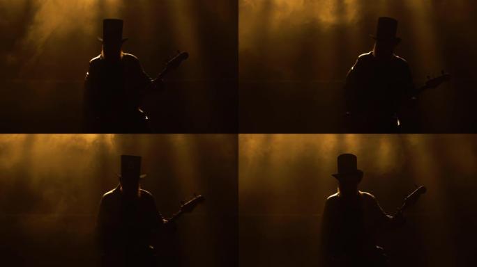 摇滚音乐家在烟雾和明亮的黄色霓虹灯中弹奏低音吉他的动态表演。穿着皮大衣和帽子的人表演现场音乐会。剪影