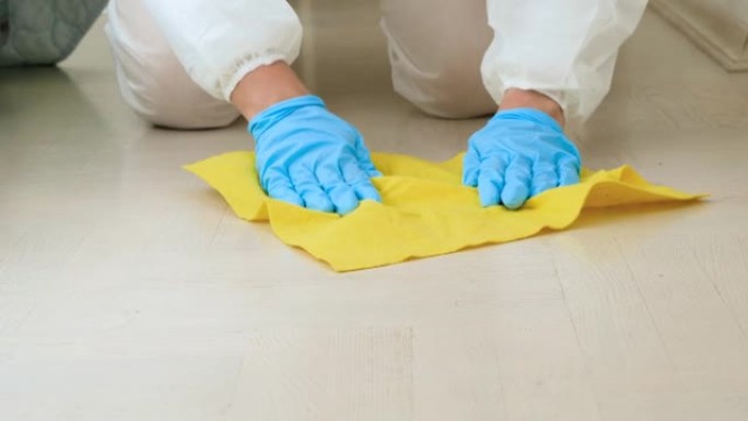 女管家或家庭主妇的特写镜头，用化学洗涤剂或清洁剂在家中消毒和清洁地板。