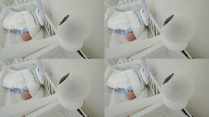 Ip摄像机作为卧室婴儿床上方的婴儿监视器摄像机，刚出生的男婴在床上安详地睡觉。