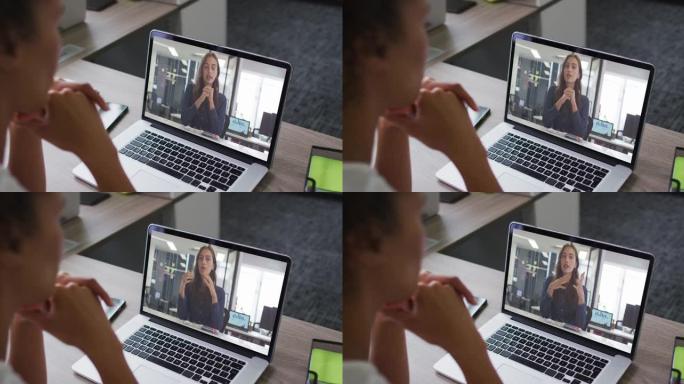 非裔美国妇女的中间部分在办公室的笔记本电脑上与女同事进行视频通话