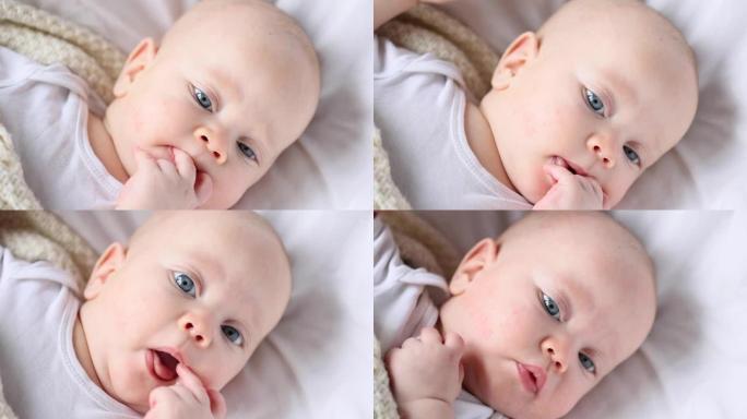 蓝眼睛婴儿吮吸手指的肖像