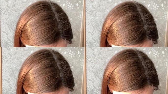 一个女人的头，有一头白发，由于检疫而长出了根。女人头上的棕色头发特写4K