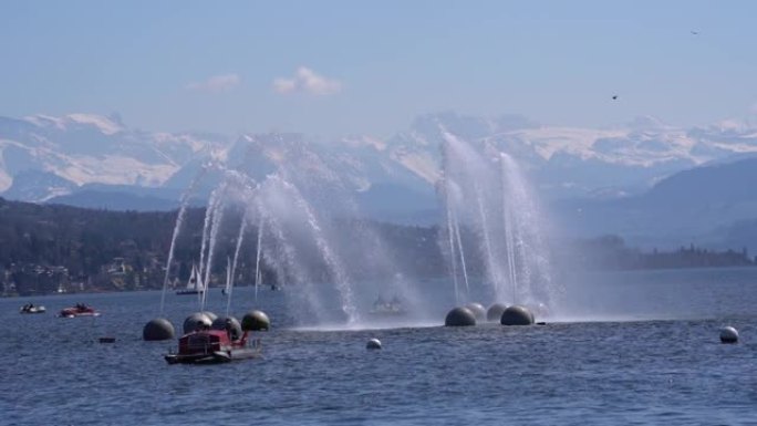 苏黎世湖的水龙卷喷泉，背景是雪山。