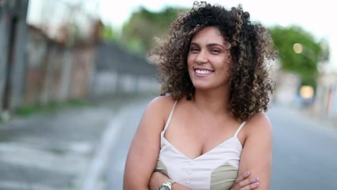 随性的巴西女人微笑着。站在外面肖像微笑的西班牙裔拉丁人