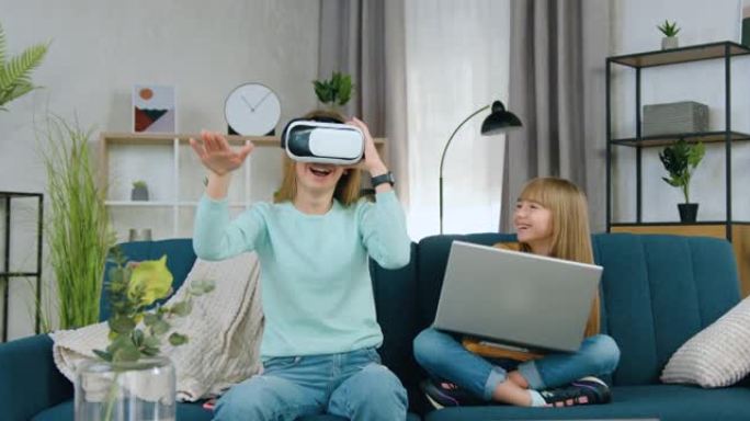 可爱的微笑现代浅色头发的20岁女孩在妹妹附近使用虚拟现实耳机，应用电脑，联合在家休闲概念
