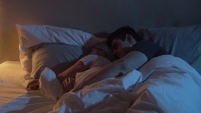 睡觉的夫妇男人拥抱拥抱妻子的床之夜
