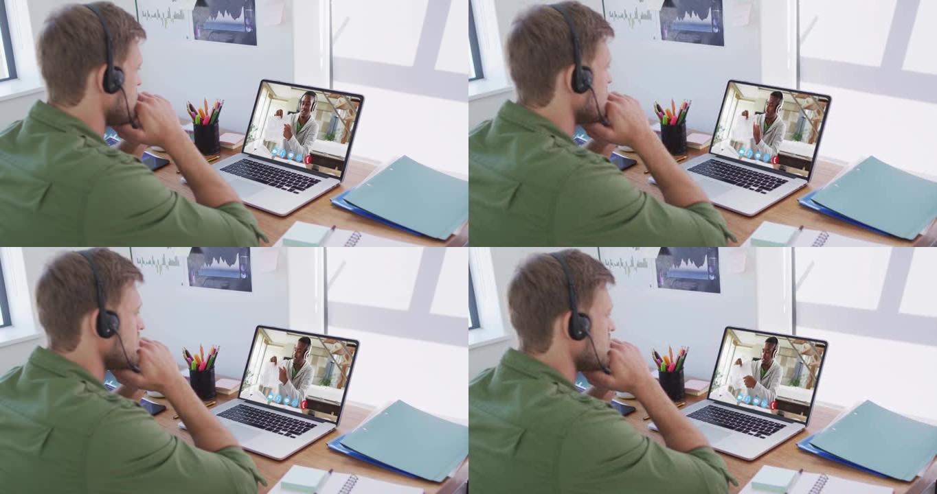 白人商人坐在办公桌前，使用笔记本电脑与男同事进行视频通话