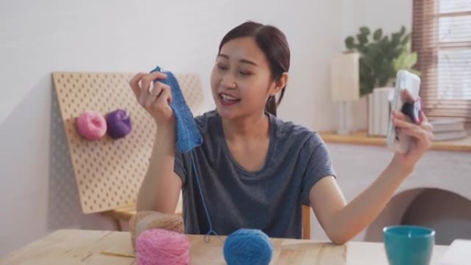 年轻的亚洲女性在客厅为自己的爱好编织钩针，在家创业