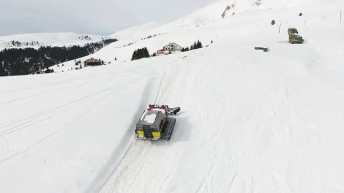 一群滑雪者和滑雪者的雪猫ratrack的空中无人机视图，在未触及的新鲜山雪上进行极端的自由骑行 (自