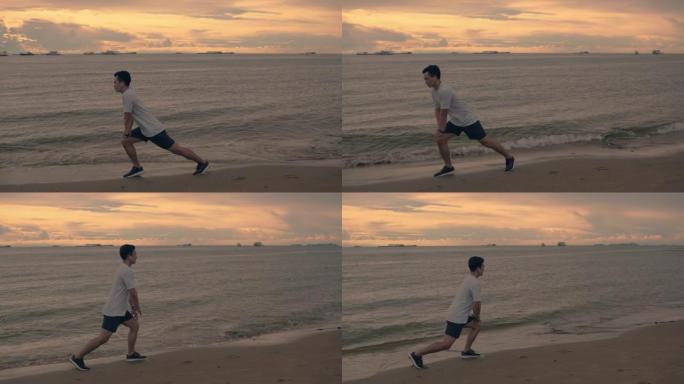 一个英俊的亚洲运动员伸展运动，然后在夏天美丽的金色天空中在海滩上跑步运动。