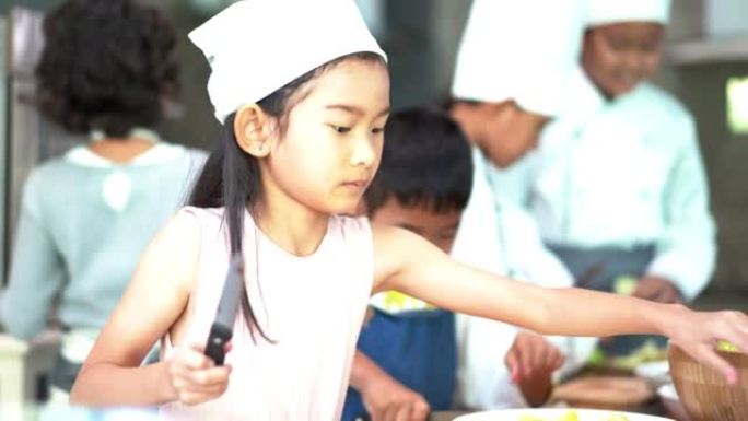 童年的学生和朋友在学校课堂上学习如何在厨房做饭