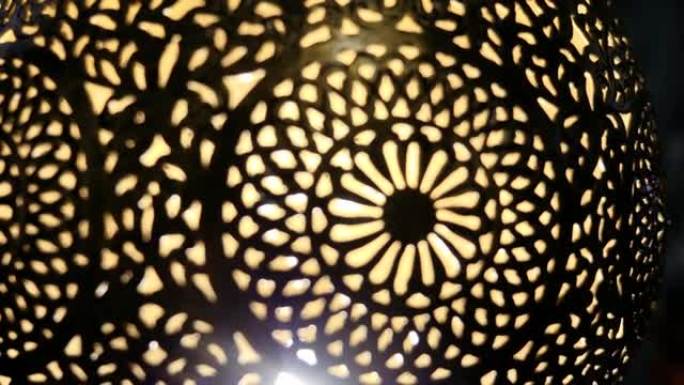 带有复杂花卉图案的点灯摩洛哥阿拉伯黄铜灯的抽象特写。
