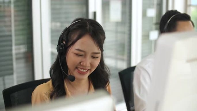 年轻的女性呼叫中心代理在其工作站上与客户交谈