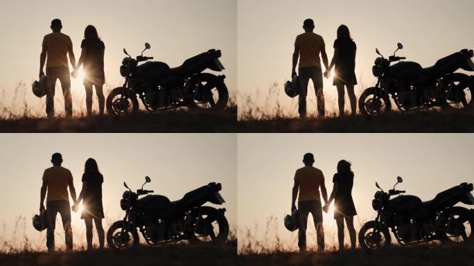一对年轻的摩托车手欣赏地平线上的日落