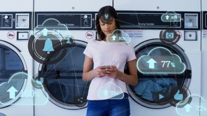 云上传图标漂浮在自助洗衣店使用智能手机的非洲裔美国女性