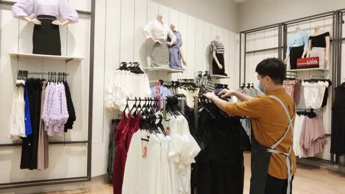 亚洲华人女性精品店服装店老板工作整理服装