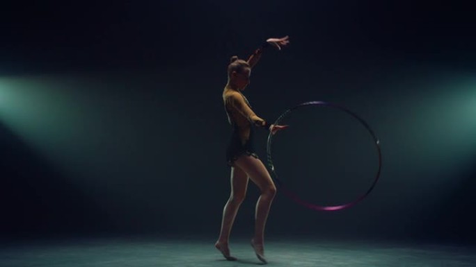 灵活的体操运动员旋转呼啦圈。练习艺术体操的年轻女子