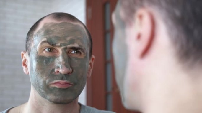 一个四十多岁的男人，脸上戴着粘土面具。