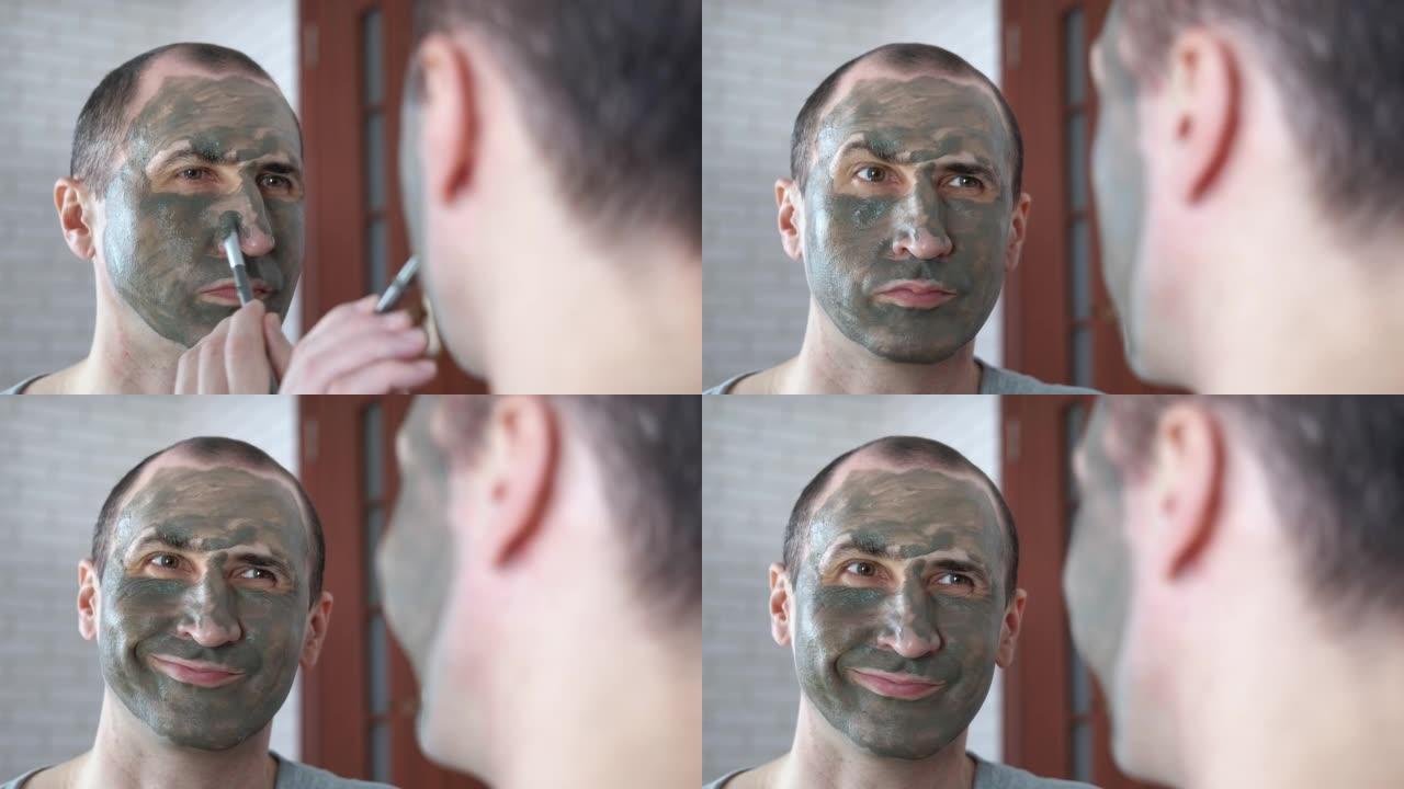 一个四十多岁的男人，脸上戴着粘土面具。