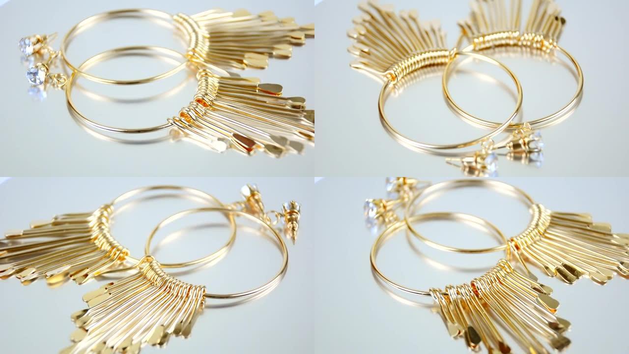 白色背景上的金色耳环，圆形，白色背景上的奢华昂贵的珠宝