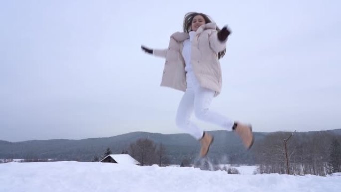 一个年轻的女孩享受生活，享受纯净的雪。在下雪的冬日里，在大自然中积极娱乐。