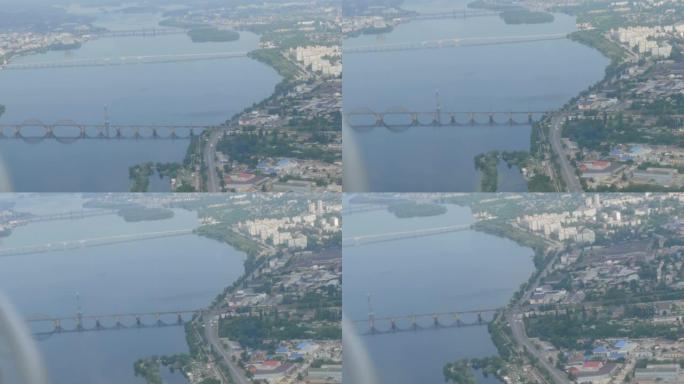 一架小型客机舷窗的视野。大都市的俯视图是第聂伯河沿岸的一条大绿色河流，其中建造了房屋和桥梁