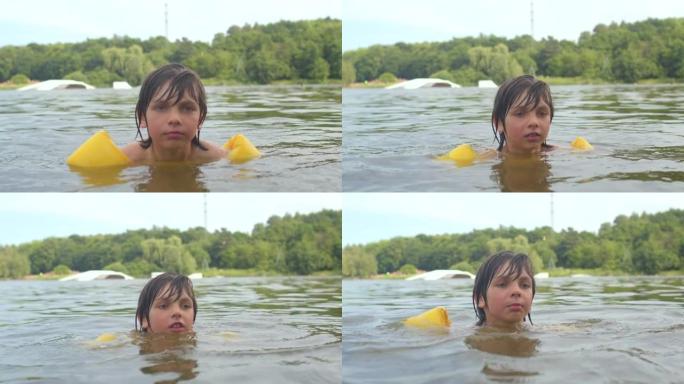 一个孩子的肖像被淹没在水中的黄色游泳漂浮物保护着。