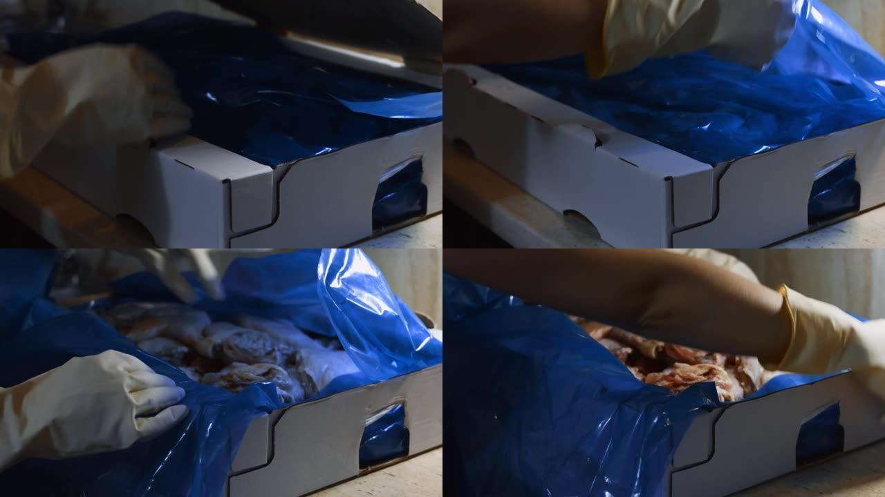 手套打开装满冷冻鸡腿的盒子的手的特写视图。用冰覆盖的冷冻生鸡肉。4k视频