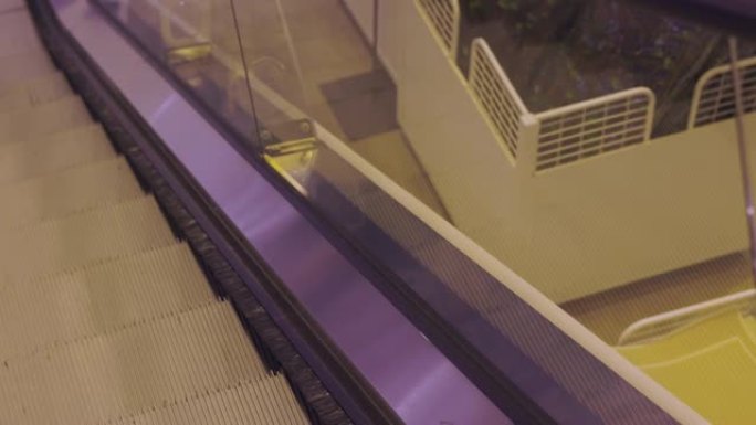 百货公司的顶视图金属escalade正在走下楼梯，透过玻璃窗观察建筑物内部。城市生活是在购物和放松中
