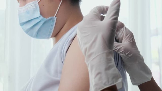 亚洲男孩戴口罩在医生办公室应用新型冠状病毒肺炎疫苗，健康的生活方式理念。