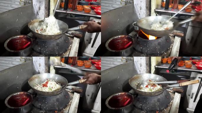 厨师在市场上的热锅里用面条油炸蔬菜和非蔬菜，鸡肉面条，厨师准备现成的鸡肉面条
