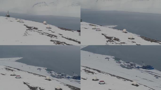 白雪皑皑的山顶上的小屋和卫星塔