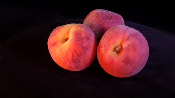 三个成熟的桃子在紧密的背景下旋转。