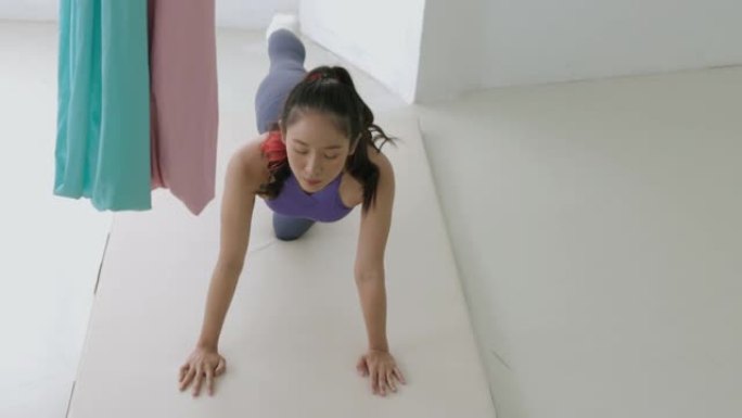 年轻的亚洲女孩弯腰单腿伸展。瑜伽床垫-股票视频