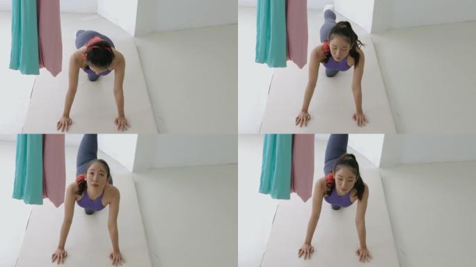 年轻的亚洲女孩弯腰单腿伸展。瑜伽床垫-股票视频