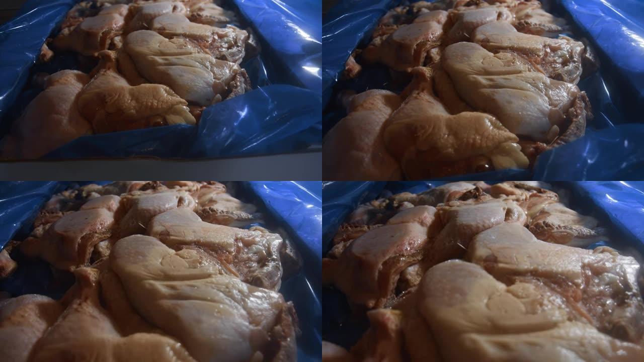 一个装满冷冻鸡腿的盒子的特写视图。用冰覆盖的冷冻生鸡肉。4k视频