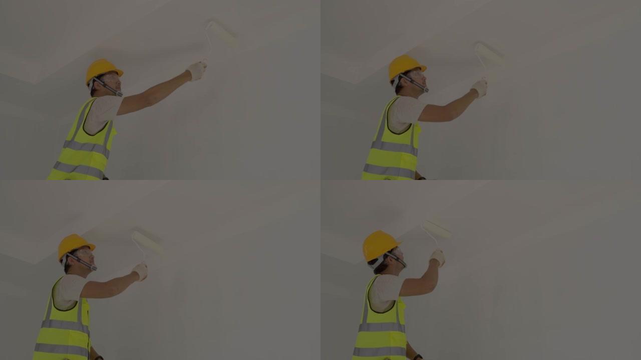 亚洲工人使用滚筒在施工现场粉刷墙壁。