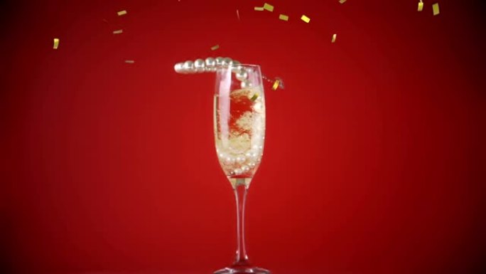 红色背景上金色五彩纸屑和珍珠项链掉进香槟杯的动画