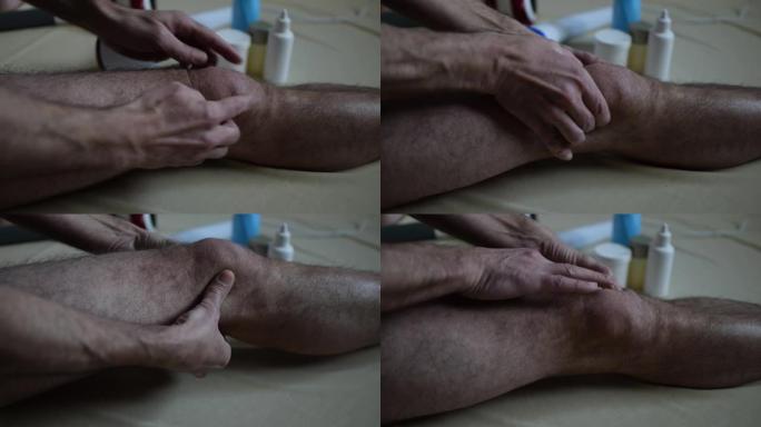 男子涂抹奶油和按摩受伤的膝盖。