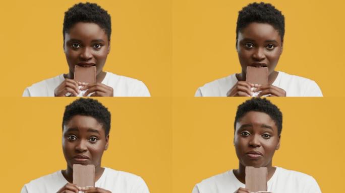 肥胖的非洲裔美国女士在黄色工作室背景下吃巧克力